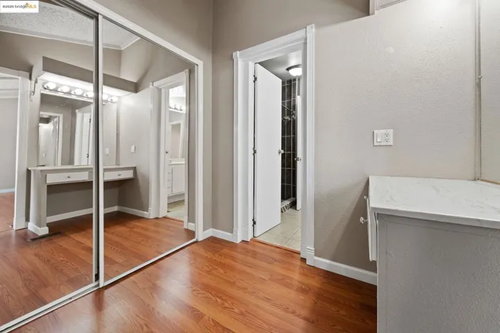 Corridor featuring light wood finished floors and a textured wall