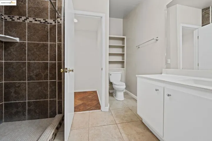 Full bath featuring vanity, a stall shower, and light tile patterned floors