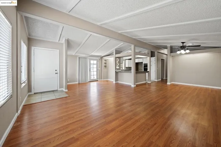 Unfurnished living room with ceiling fan and light wood-style floors