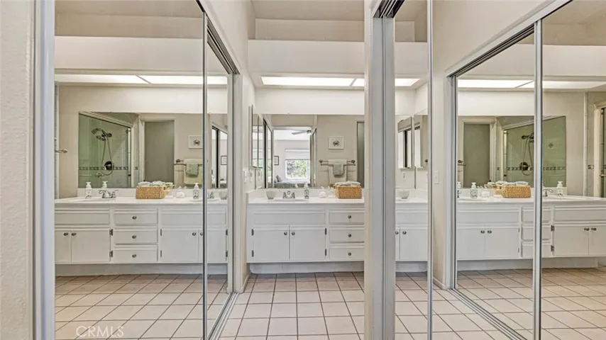 Dual closets in primary bedroom with mirrored doors