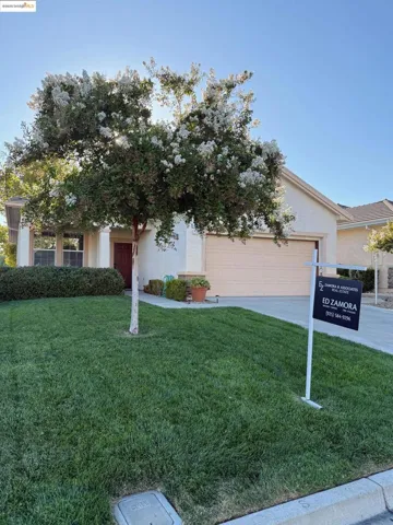 Obstructed view of property featuring stucco siding, concrete driveway, a front yard, and an attached garage