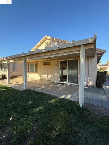 Back of property with a yard and a patio area