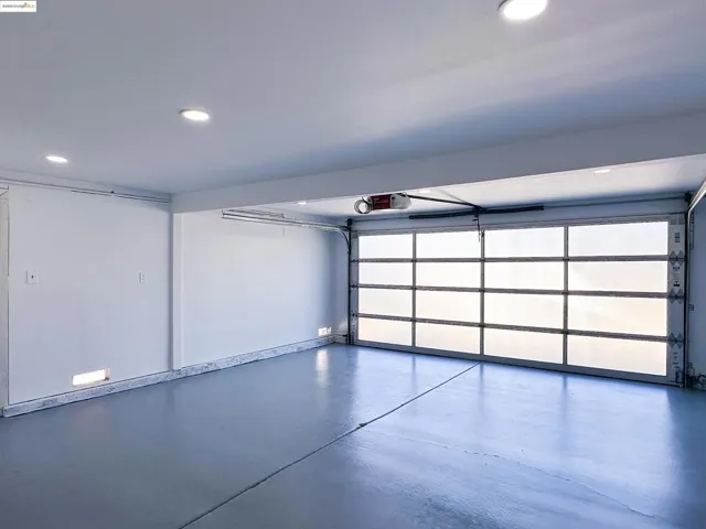 Garage featuring recessed lighting epoxy floor and a garage door opener