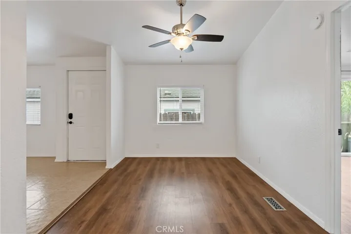 The dining area has laminate wood floors and a ceiling fan.