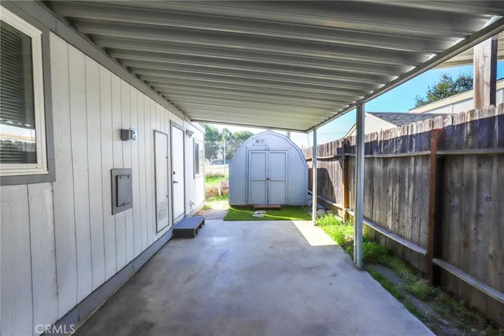 Relax outside on the covered patio. Notice the shed for additional storage.