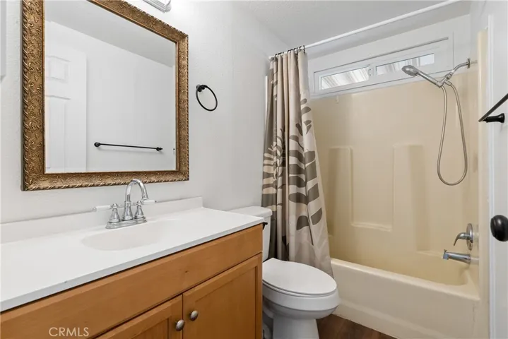 The main bathroom has an updated vanity, laminate wood floors and a tub/shower combination.