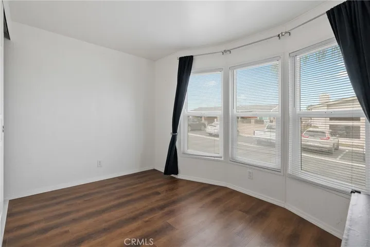Bedroom 3 has laminate wood floors and bay windows.