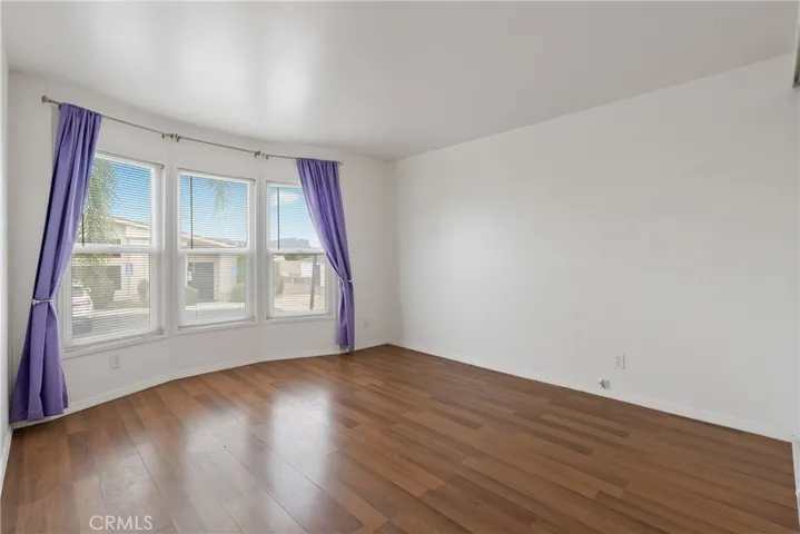 Bedroom 2 has laminate wood floors and a bay window.