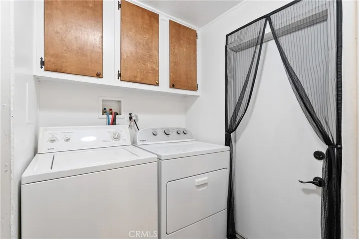 Off the kitchen is the laundry room with cabinets and a door to the outside. Washer and dryer stay!