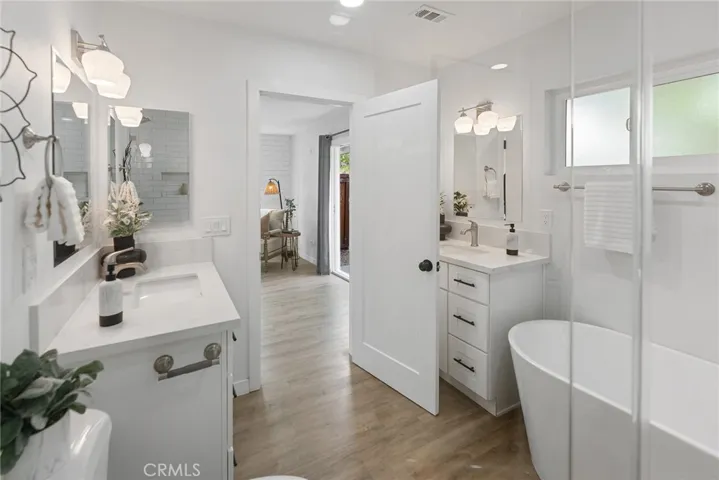 This gorgeous bathroom has a freestanding tub, separate tiled shower, and 2 vanities