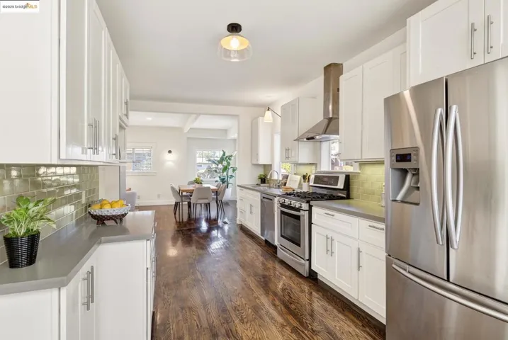 Kitchen with hardwood floors, quartz countertops, stainless appliances