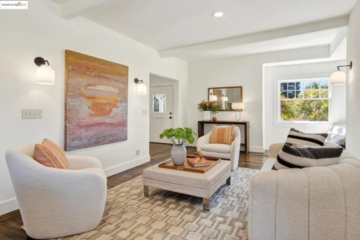 Living area featuring beamed ceiling, hardwood floors