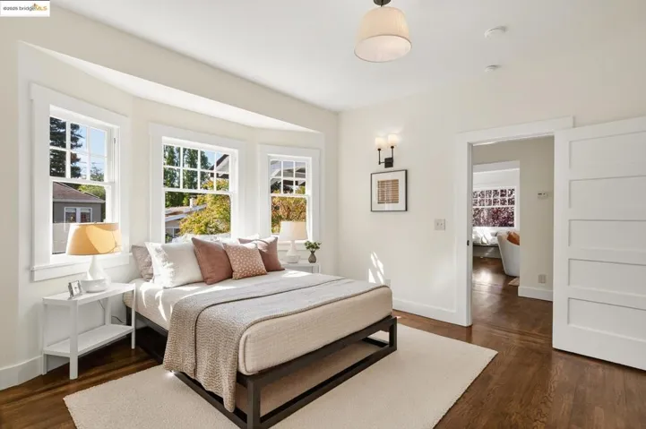 Main level primary bedroom, with hardwood floors and additional dressing room/office