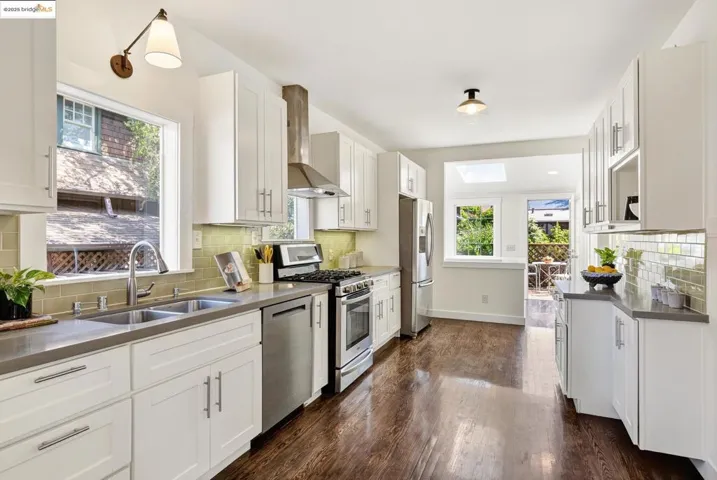 Kitchen with hardwood floors, quartz countertops, stainless appliances