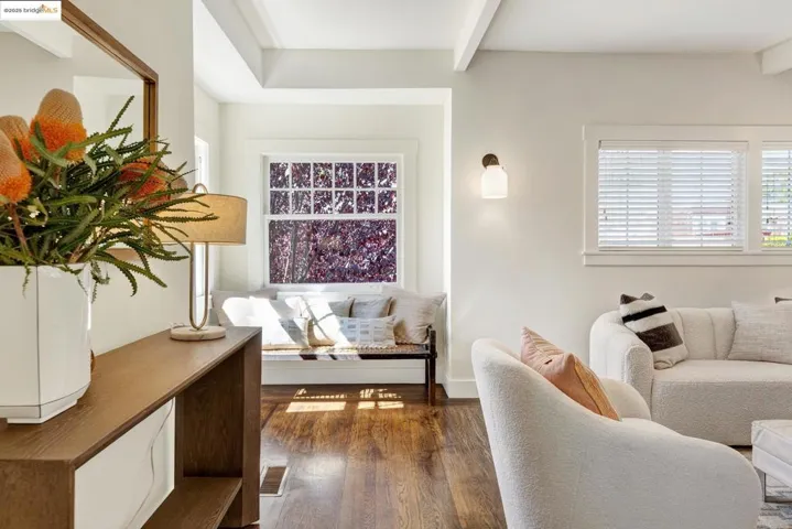 Living room featuring hardwood floors, beamed ceiling, and plenty of natural light