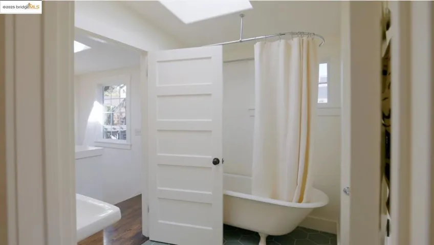 Main level bathroom with clawfoot tub and skylight