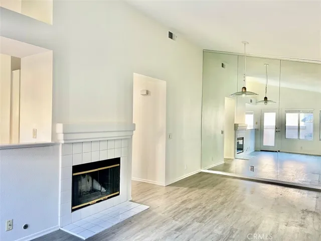 Living room and dining room with floor to ceiling mirrored wall.