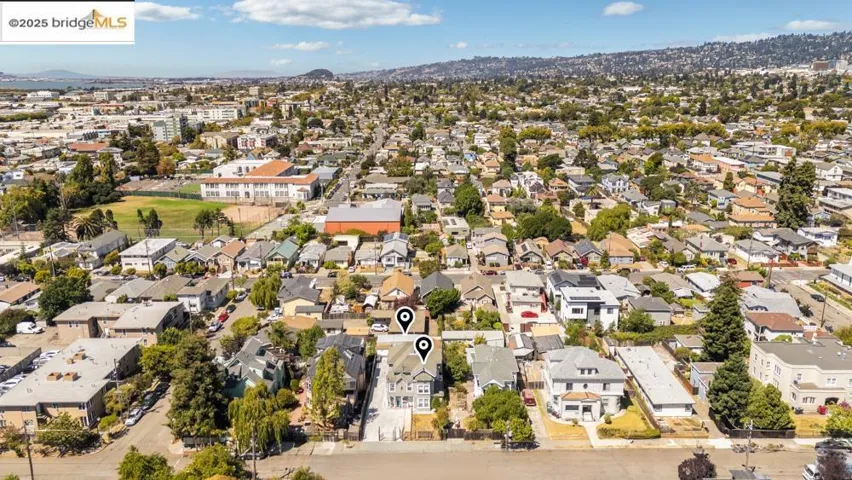 Aerial view of property and surrounding area with nearby suburban area and mountains