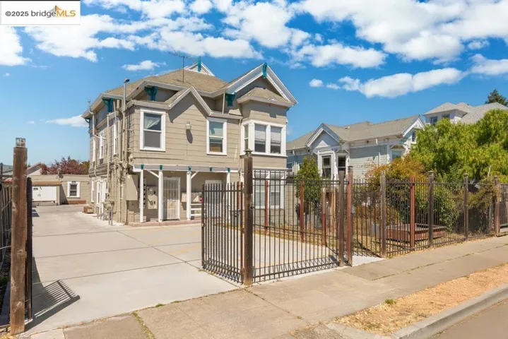 View of front facade with a fenced front yard, a gate, and driveway