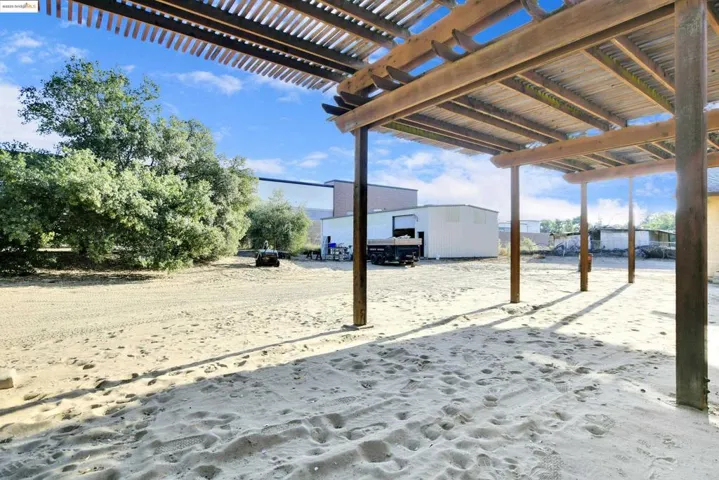 View of yard featuring a pergola and an outbuilding