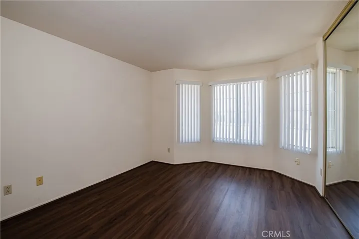 Front bedroom with bay windows and mirrored closet doors.