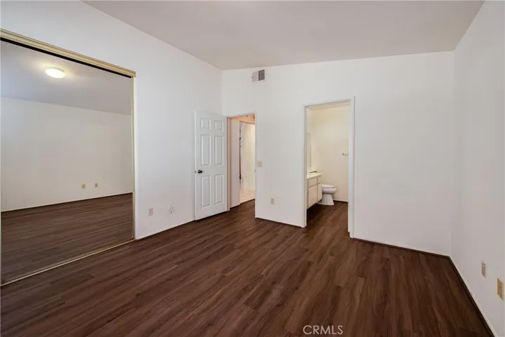 The back master bedroom has wood type laminate floors and mirrored closet doors.