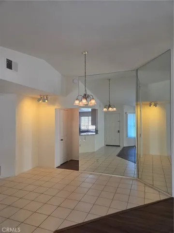 Dining room with tile floors and floor-to-ceiling mirrors.