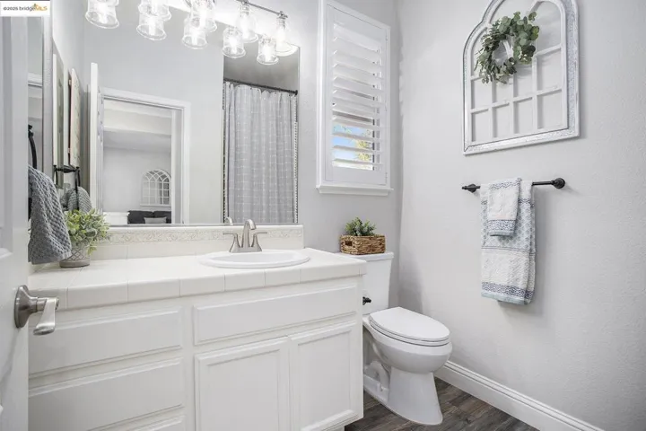 Bathroom located next to bedroom 4 with vanity, step-in shower, and shutters.