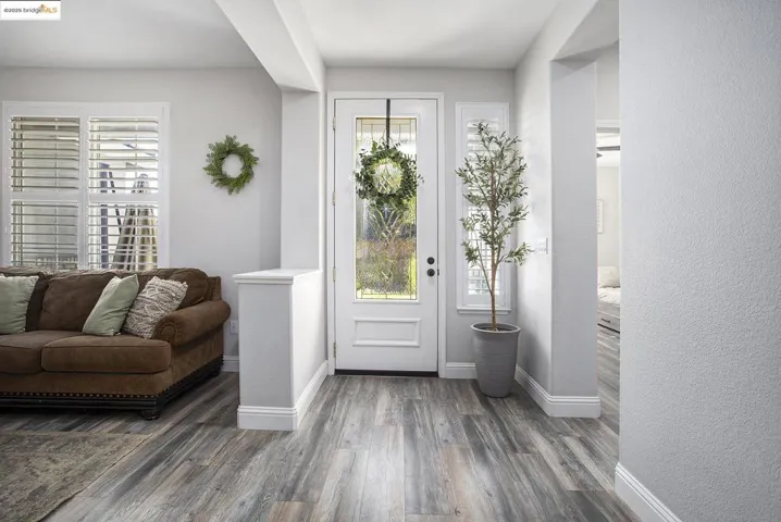 Foyer with laminate wood-style finished floors and a textured wall