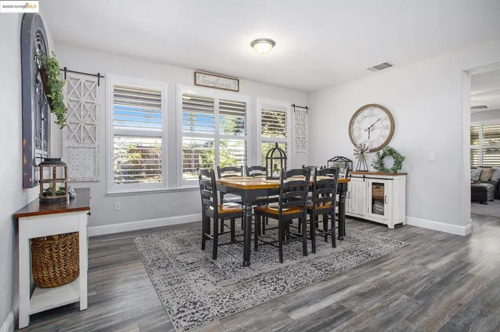 Dining space featuring laminate wood-style floors and 5 1/2 in. baseboards, with Plantation Shutters through-out.