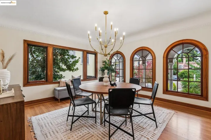 Dining space with light wood-style floors, a chandelier, and ornamental molding