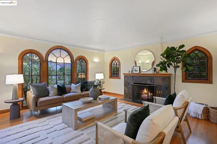 Living area featuring wood finished floors, a tile fireplace, and crown molding