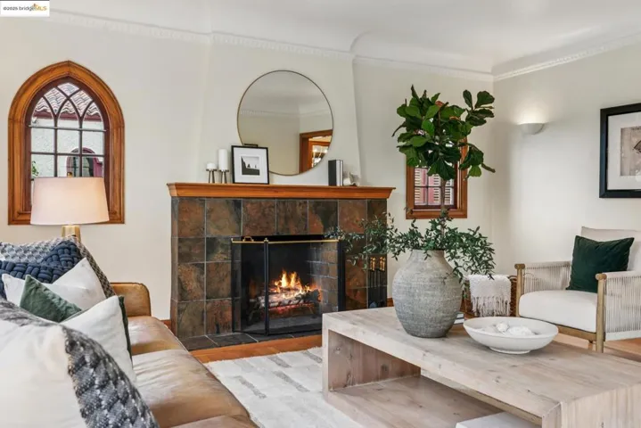 Living area featuring wood finished floors, a tiled fireplace, and ornamental molding