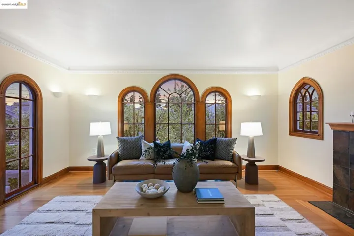 Living area with crown molding, a tile fireplace, and wood finished floors