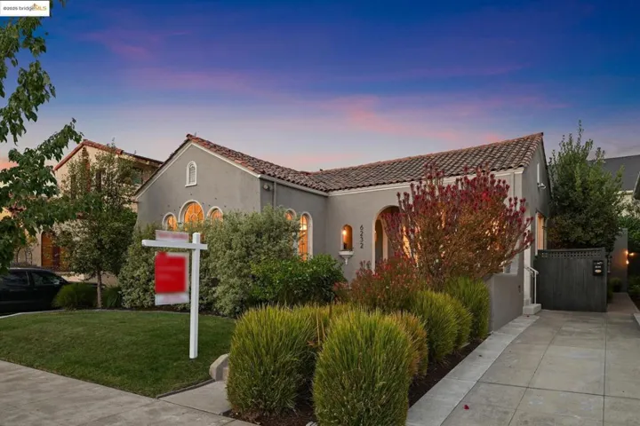 Mediterranean / spanish-style house with a tiled roof, stucco siding, and a front lawn