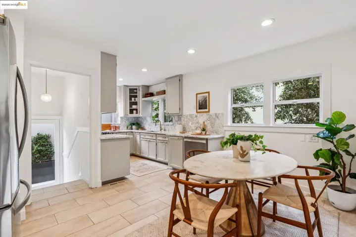 Kitchen with backsplash, stainless steel appliances, wood finish floors, recessed lighting, and light stone countertops