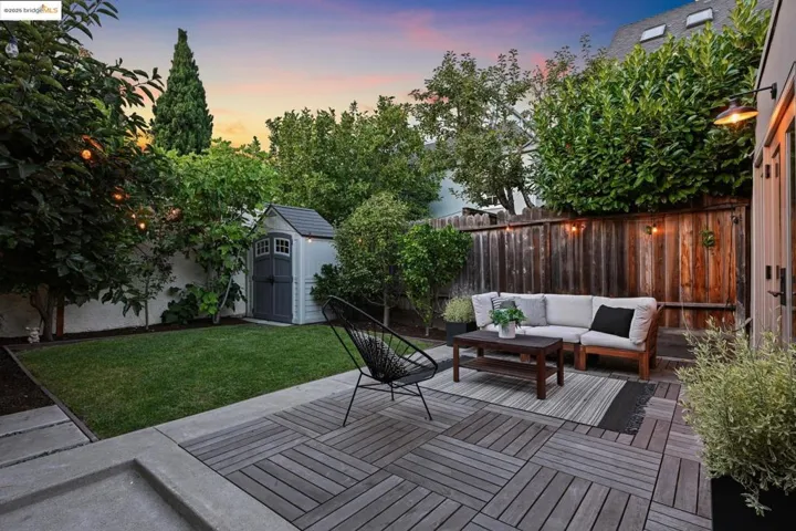 Wooden terrace with a storage unit, an outdoor living space, and a fenced backyard