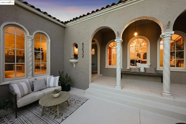 Patio terrace at dusk with an outdoor hangout area and covered porch