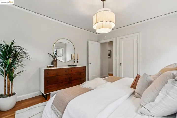 Bedroom featuring wood finished floors and crown molding
