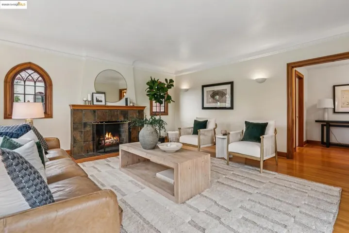 Living area with wood finished floors, a fireplace, and ornamental molding