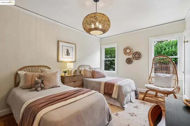 Bedroom with wood finished floors, ornamental molding, and a chandelier