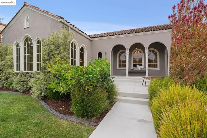 Property entrance with a porch, a tile roof, and stucco siding