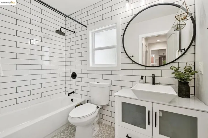Bathroom featuring  shower combination, tile walls, vanity, and tile patterned floors