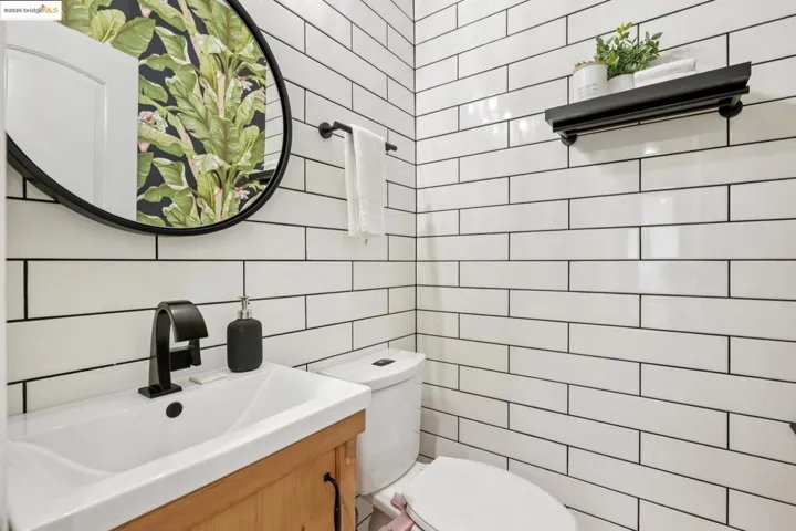 Half bath featuring vanity, tile walls, and tasteful backsplash