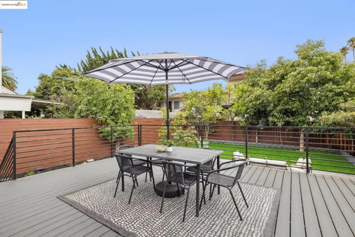 Wooden terrace with outdoor dining space and a fenced backyard