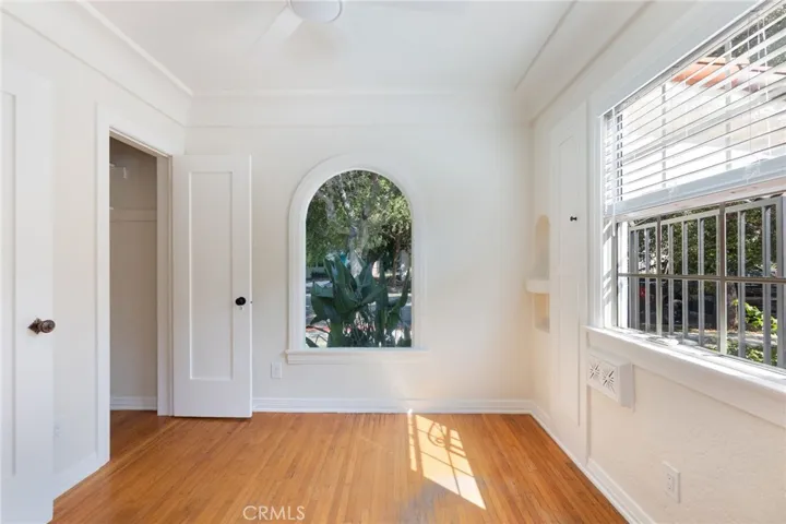 Bedroom one with arch window, built in storage, and large closet.