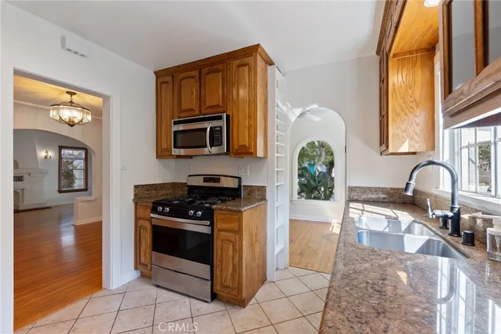 Kitchen with granite countertops and built in floor to ceiling spice rack.