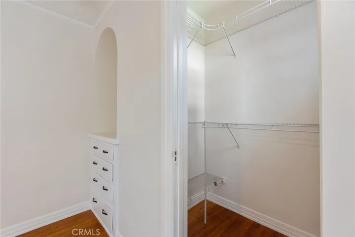 Primary walk in closet with extra built in storage. Can’t forget the the awesome arch.
