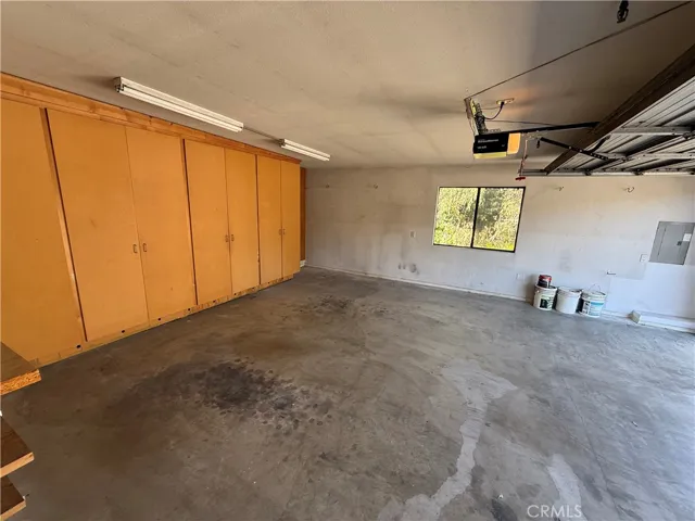  Garage with ample storage cupboards.