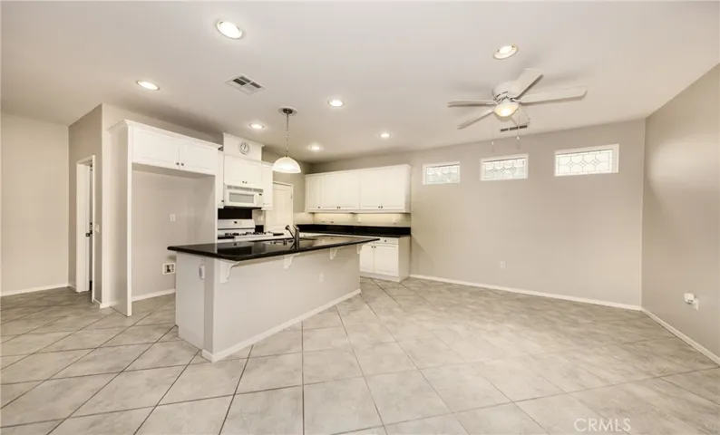 Kitchen with Island, Walk in PantryDinning Area with Ceiling Fan and Tile Flooring